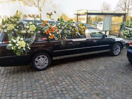 Corbillard Cadillac noir devant église vu du coté droit